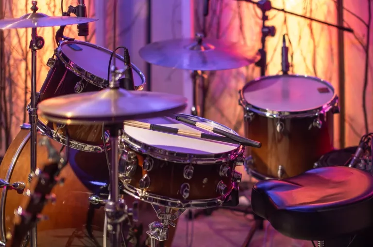 Drum kit and cymbals on a lit stage